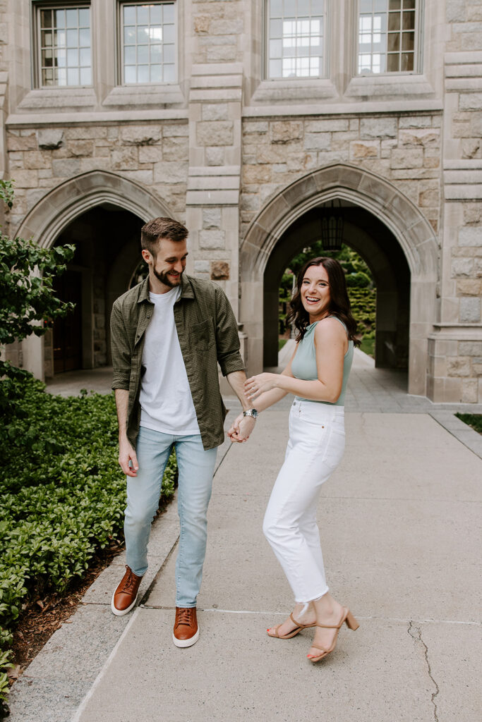 ride-to-be in white dress walking alongside fiancé on campus path