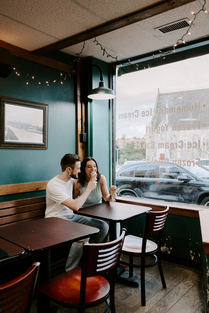 couple playfully eating icecream in a shop