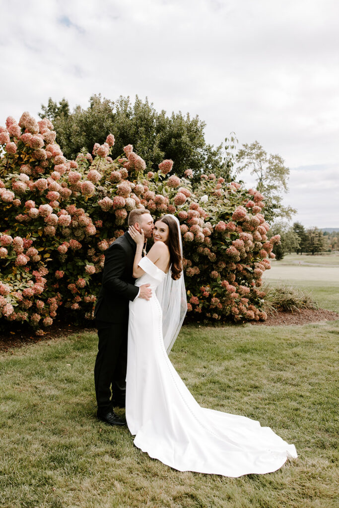 Groom kissing bride on the forehead during portraits