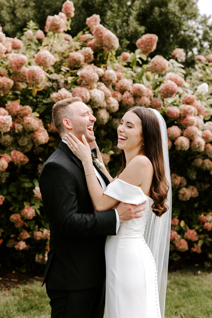 Bride and groom sharing a candid laugh in natural light