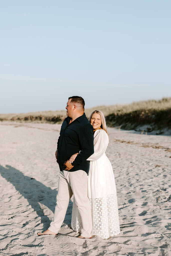 Couple smiling and looking at each other in soft sunset light