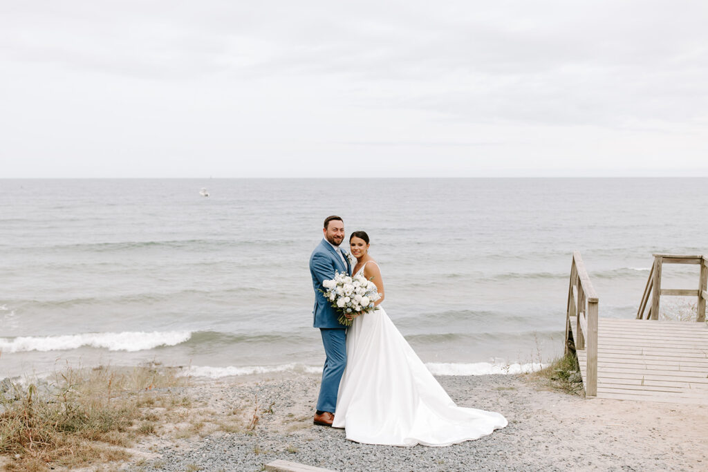 wide shot of bride and groom on cliffside