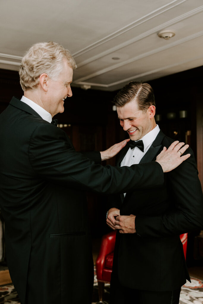 grooms father adjusting his tuxedo