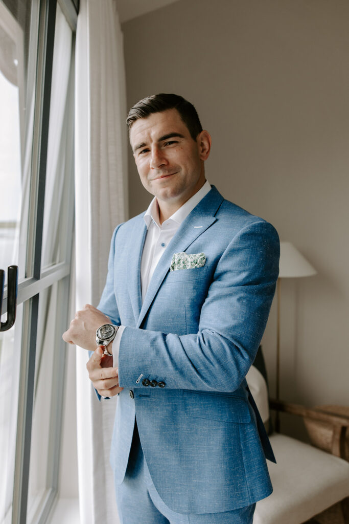 Groom fastening his custom suit jacket from Regan Clothiers before seeing his bride