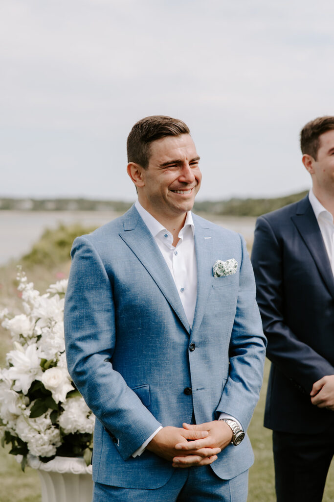 Groom tearing up as he watches his bride walk down the aisle at their intimate backyard wedding