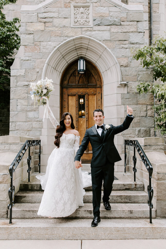 Couple walking out of church surrounded by cheering guests