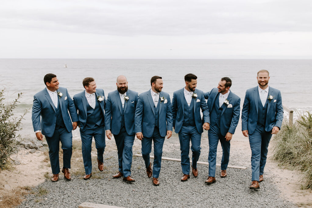 groomsmen walking along the beach