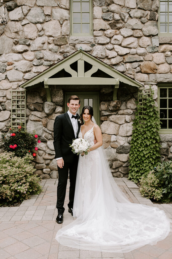 bride and groom smiling in front of willowdale estate courtyard