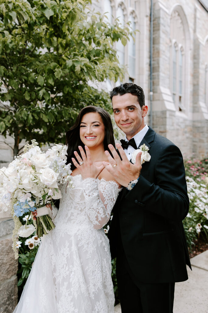 bride and groom showing off their new rings after ceremony