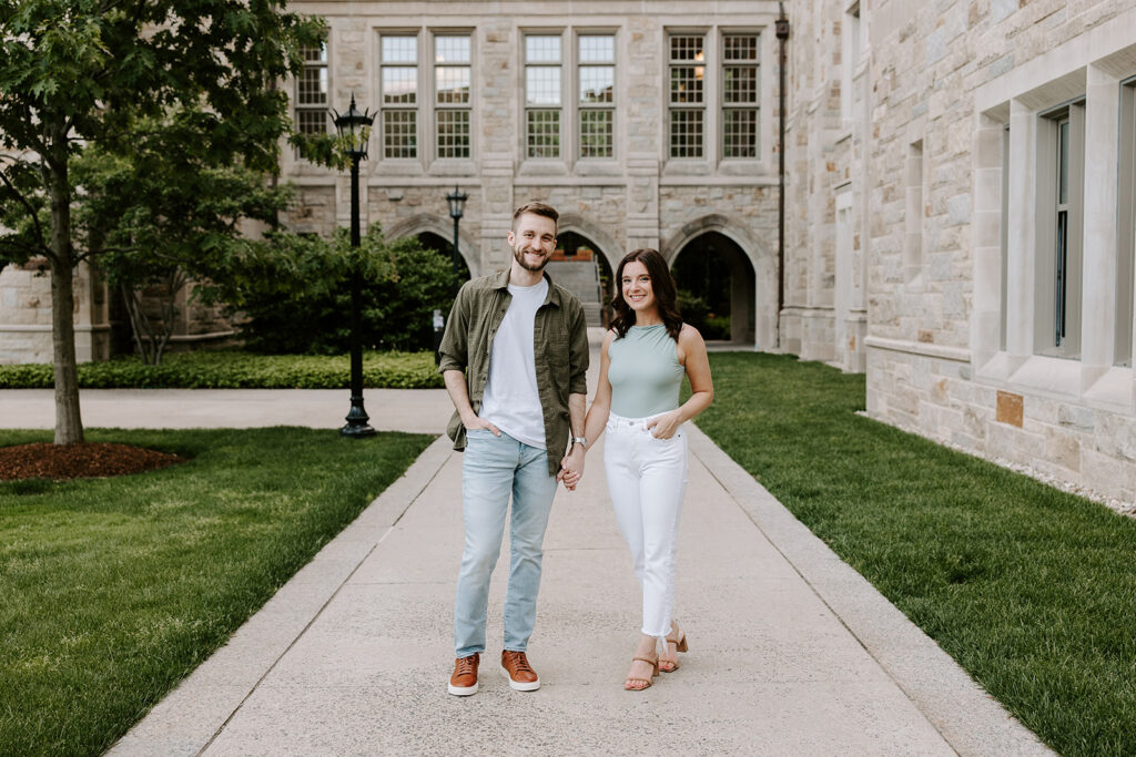 Couple in casual outfits smiling on Boston College lawn