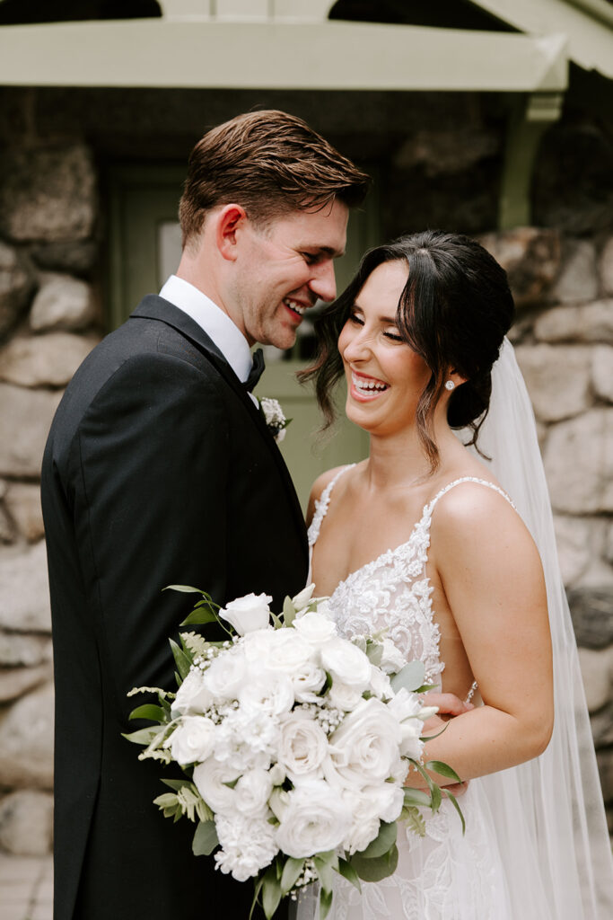 bride laughing as groom whispers in her ear