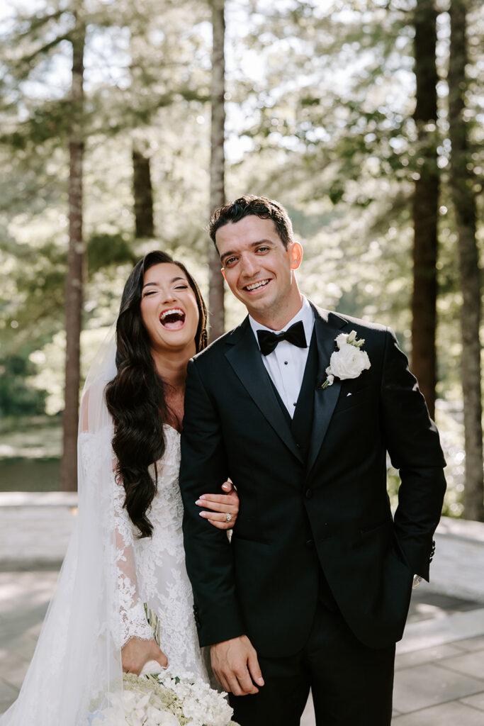 newlyweds laughing joyfully with greenery behind them
