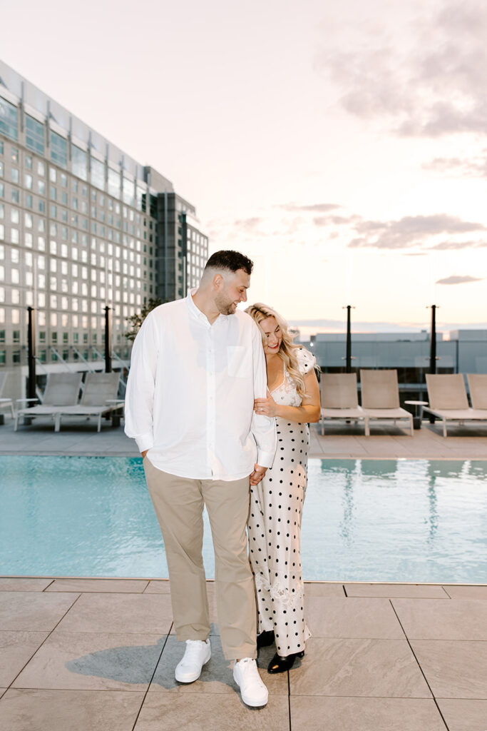 Engaged couple striking a playful pose in a stylish corner of the Omni Hotel Seapor