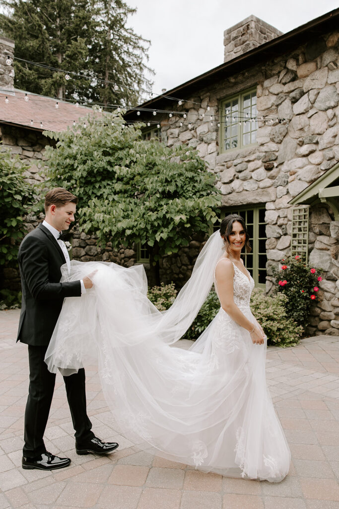 groom carrying brides gown