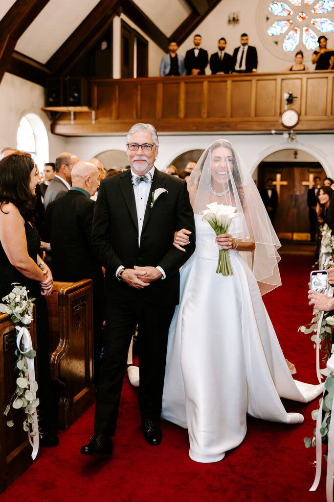 bride walking down aisle with father