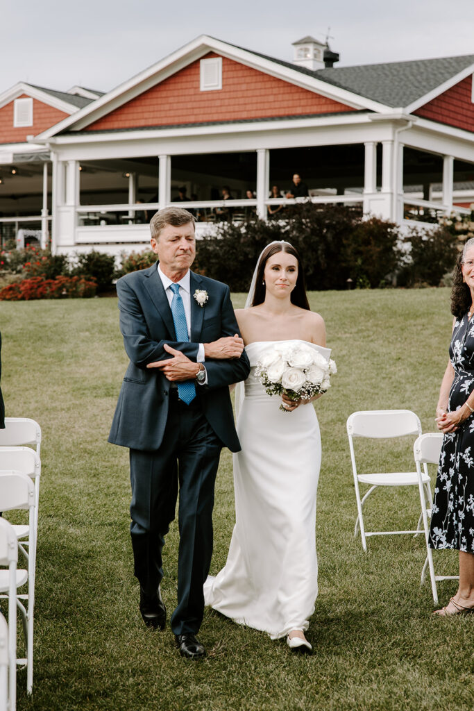 Bride walking down the aisle with soft summer light