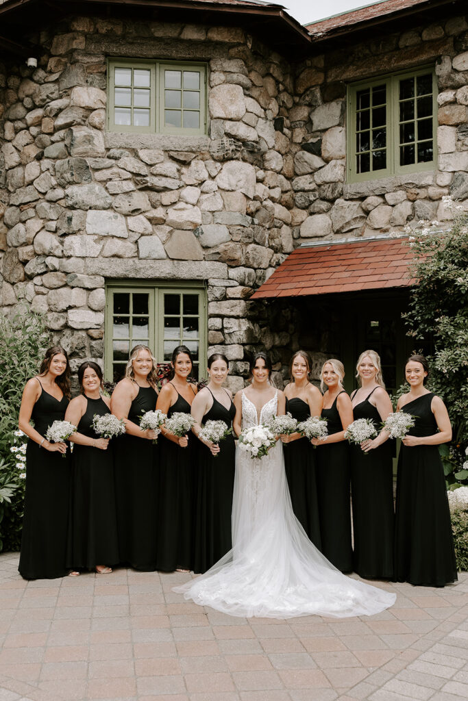 bridesmaids smiling in courtyard with white florals