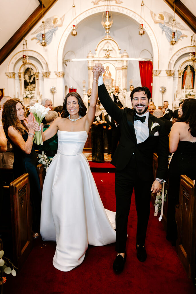 bride and groom excitedly walking down aisle seeing guests
