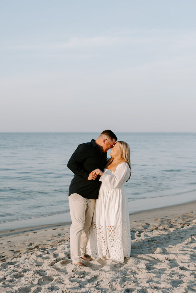 Romantic engagement portrait with couple in dressy beach outfits