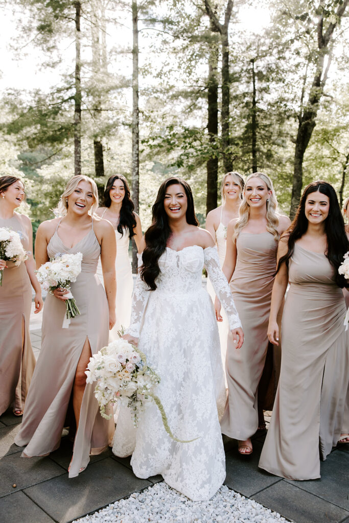 bride and bridesmaids walking and laughing toward camera