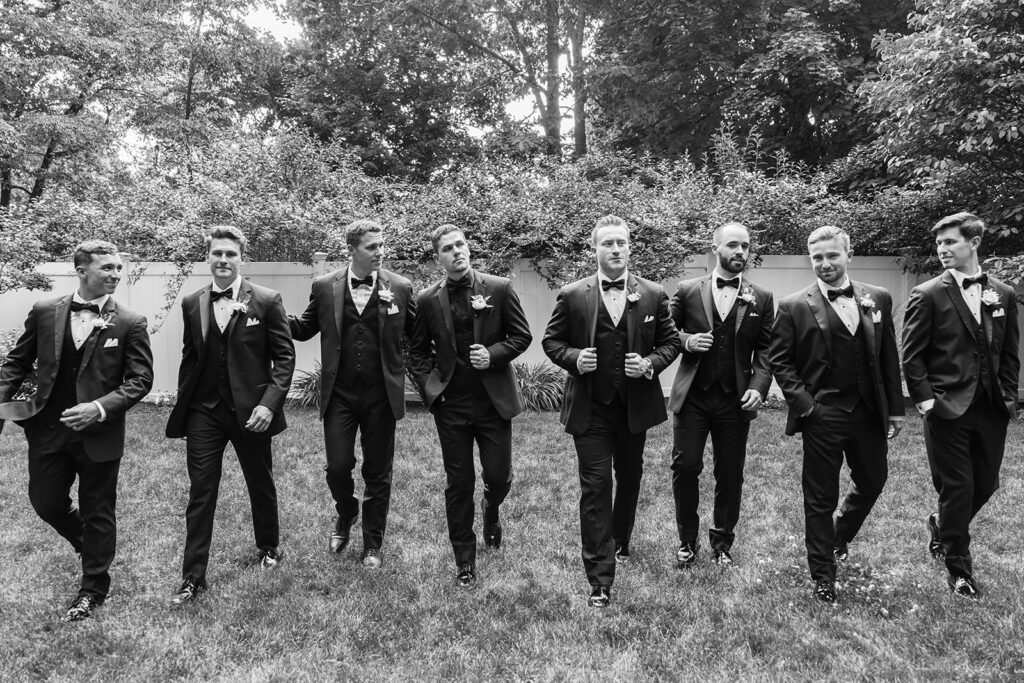 Groom and groomsmen walking and laughing together
