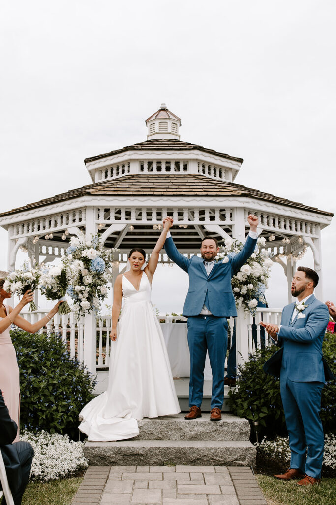 Bride and groom walking up the aisle with happy guests in the background