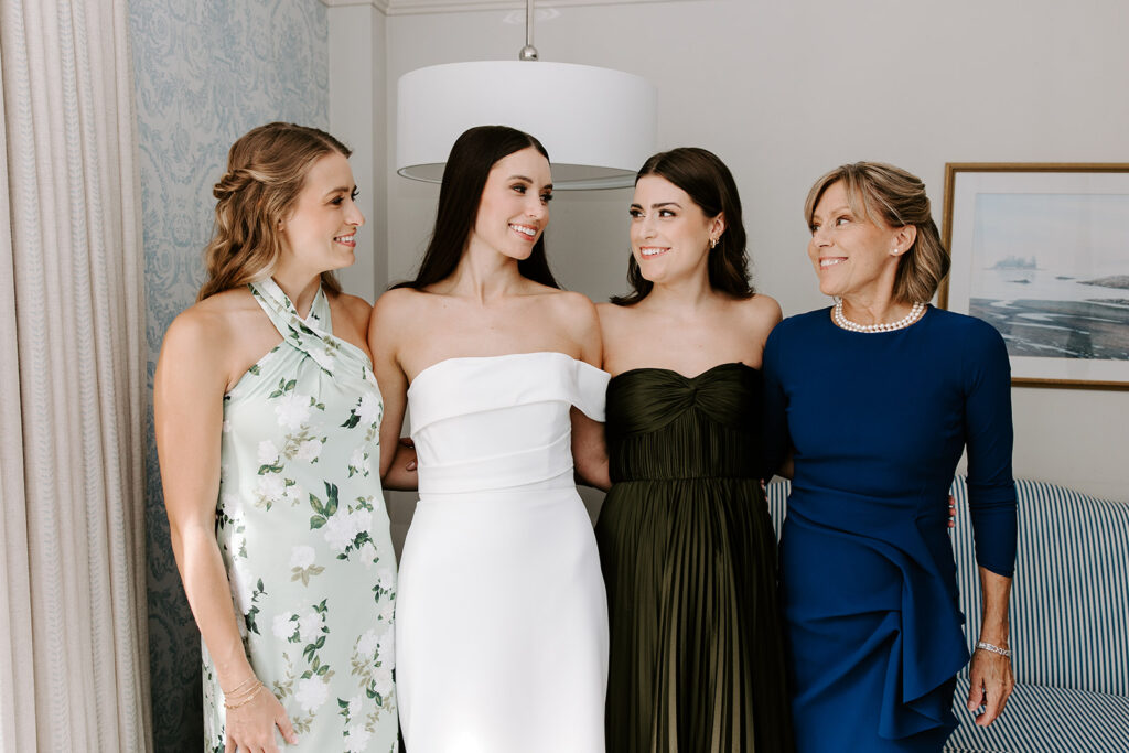 bride and bridesmaids smiling while getting ready