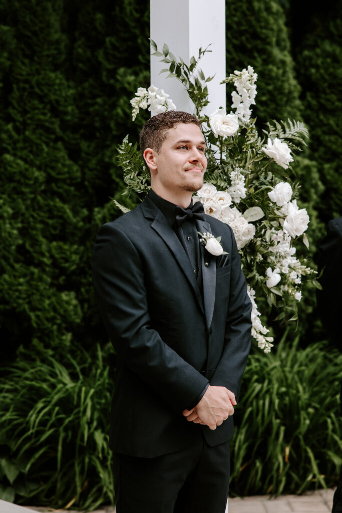 groom watching bride walk down the aisle