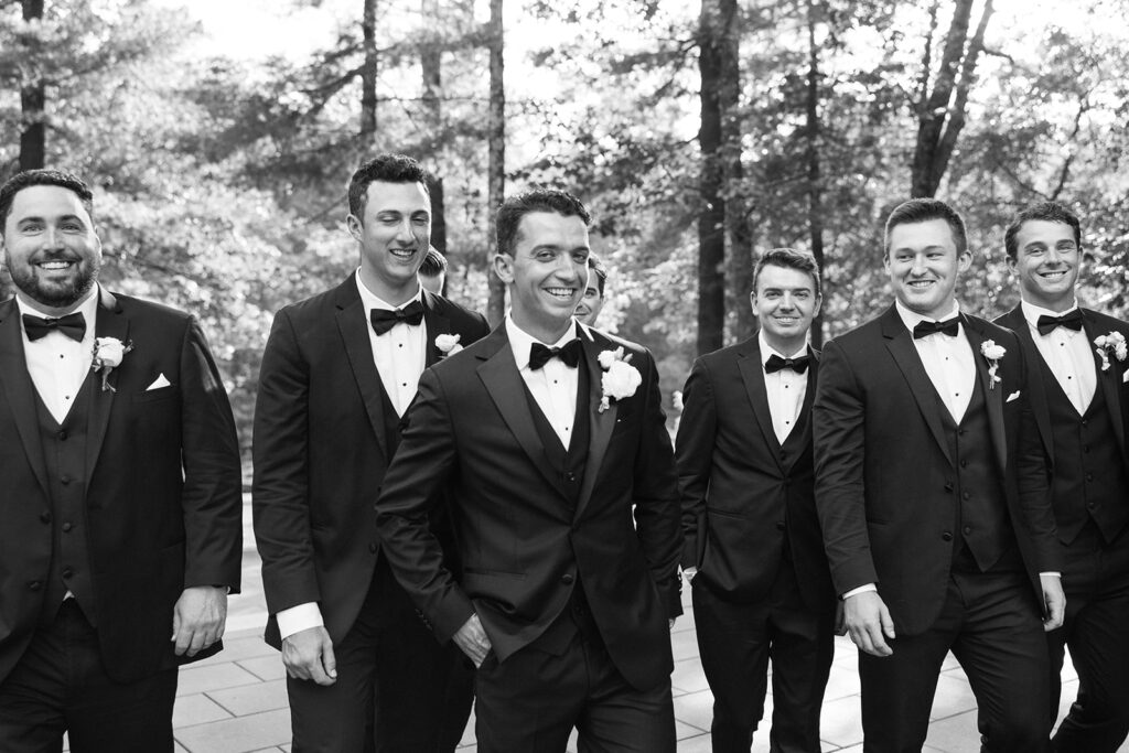 groom and groomsmen laughing and walking together