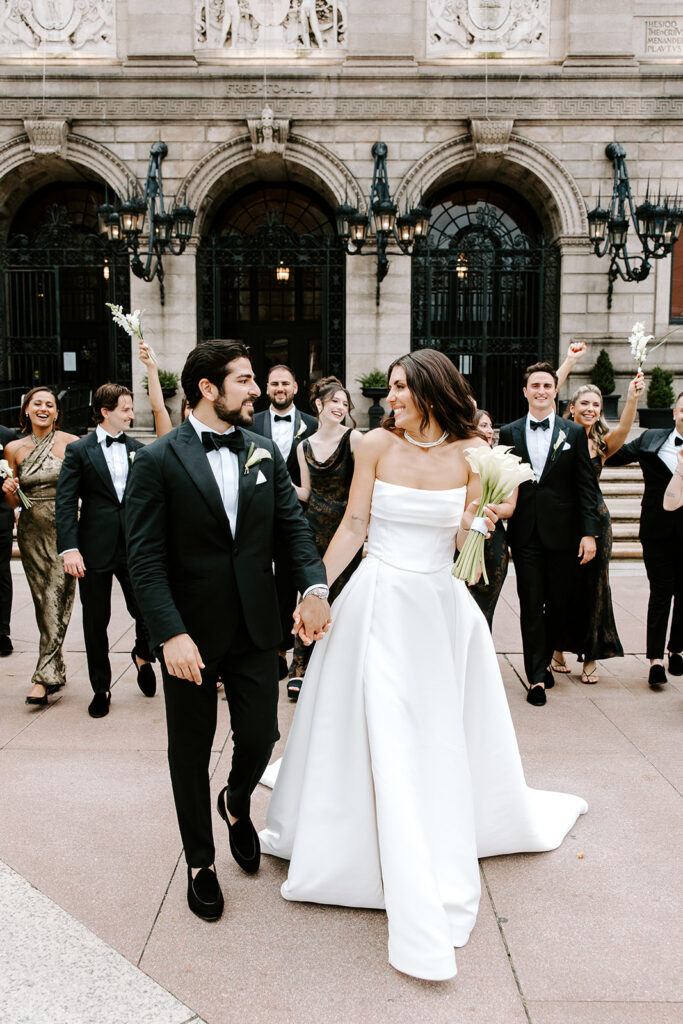 bride and groom walking with wedding party joyfully