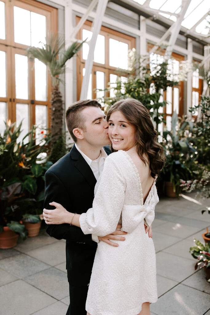 Greenhouse engagement portrait with vibrant foliage and soft lighting