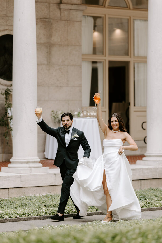 bride and groom entering cocktail hour with a drink