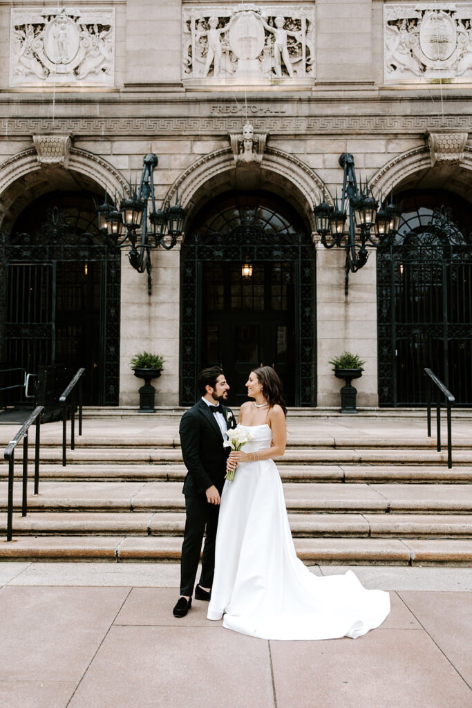 Bride and groom sharing a romantic moment in front of the Boston Public Library