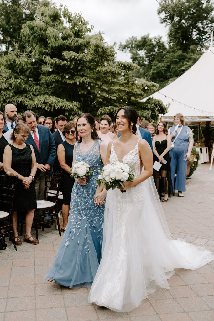 bride walking down aisle with her mom 