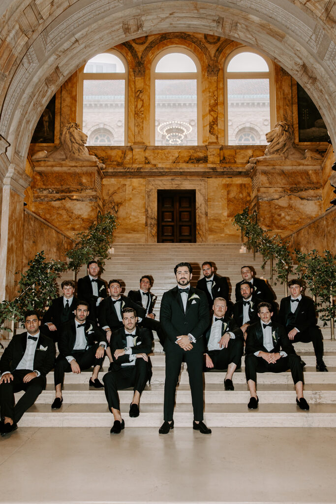 Wedding party posing on the grand marble staircase inside the Boston Public Library