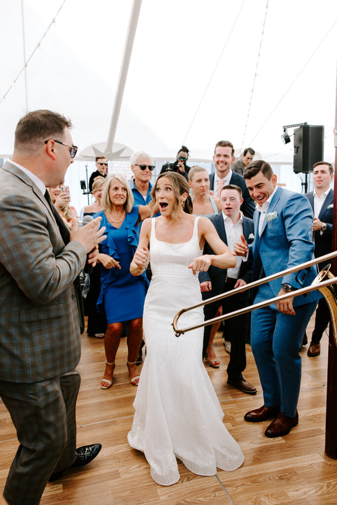 Groom and groomsmen singing along with the live band at a lively backyard wedding reception
