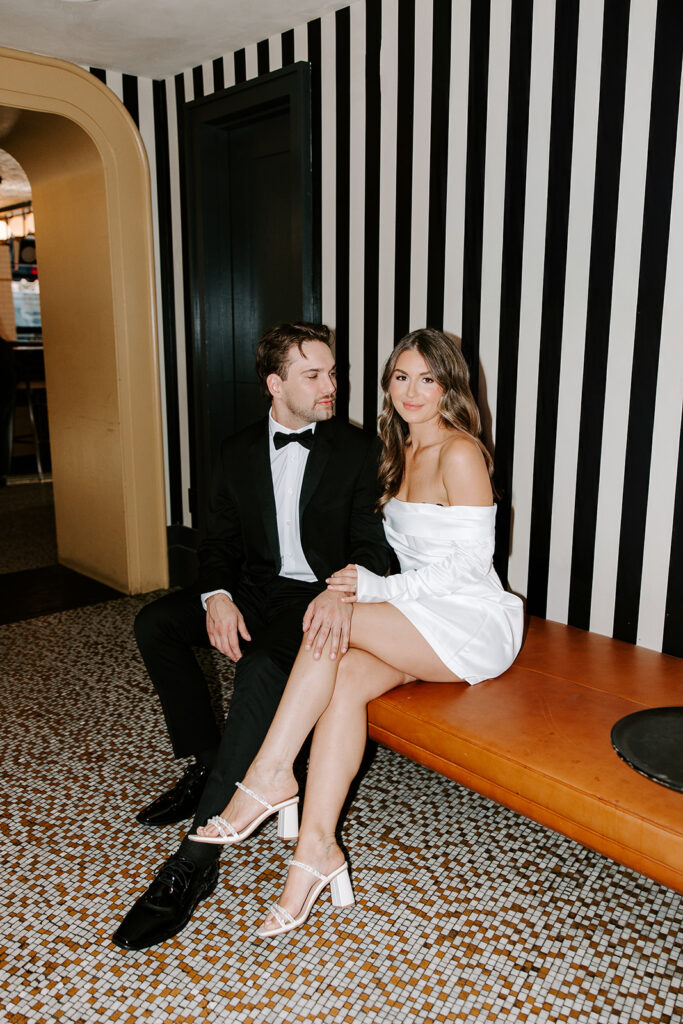 Editorial-style engagement photo at vintage bar interior