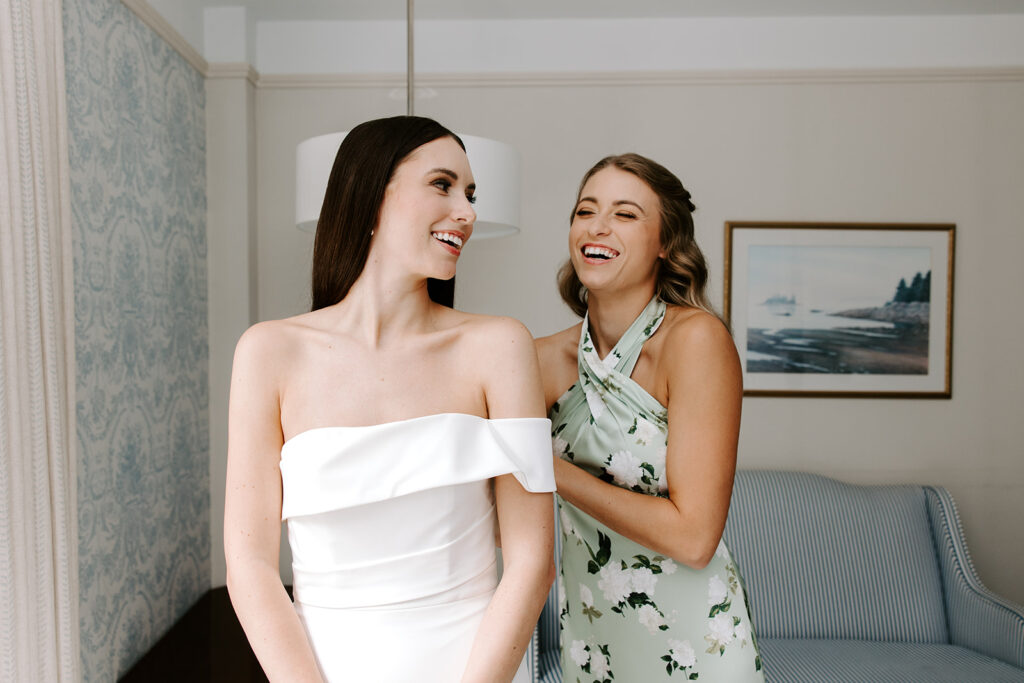 Bridesmaids helping bride into Jenny Yoo wedding gown