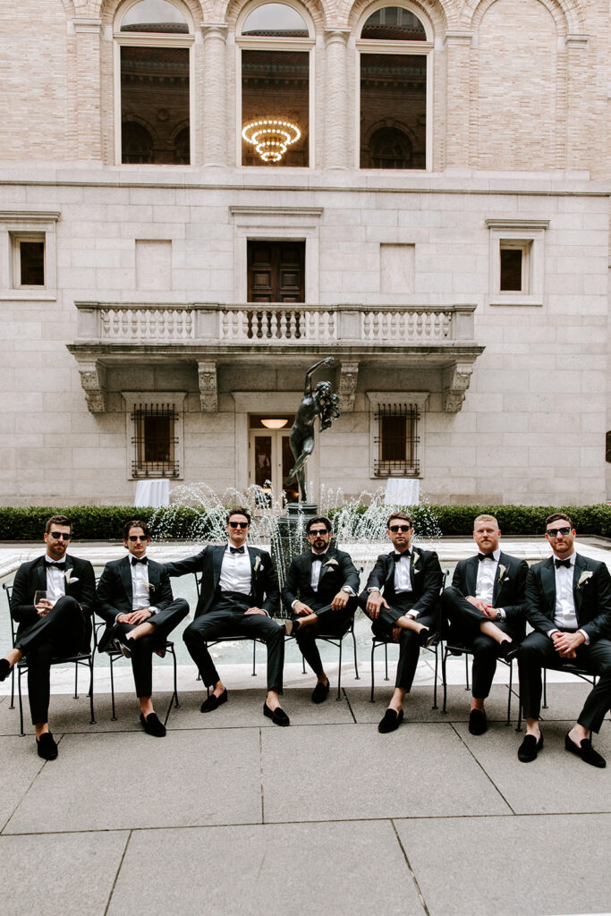 groomsmen posing in courtyard of boston public librar