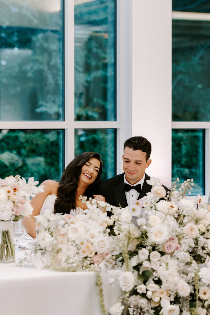 bride smiling at groom during speeches
