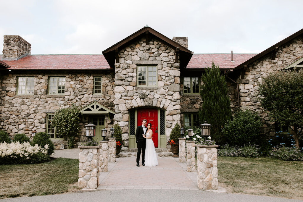 bride and groom posing in front of red door at willowdale estate