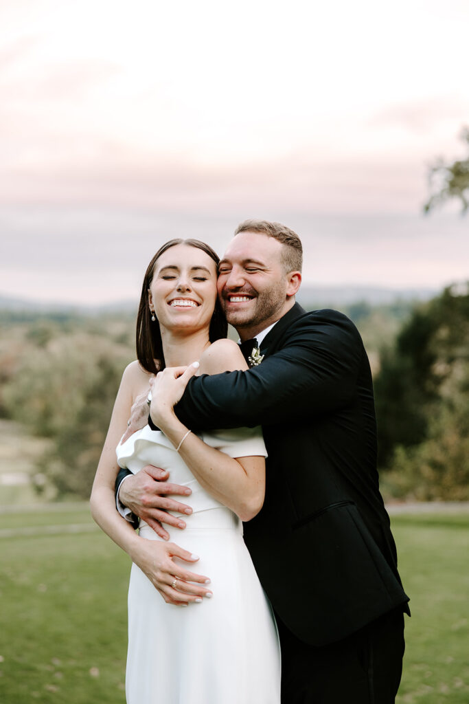 Bride and groom embracing with rolling hills in the background