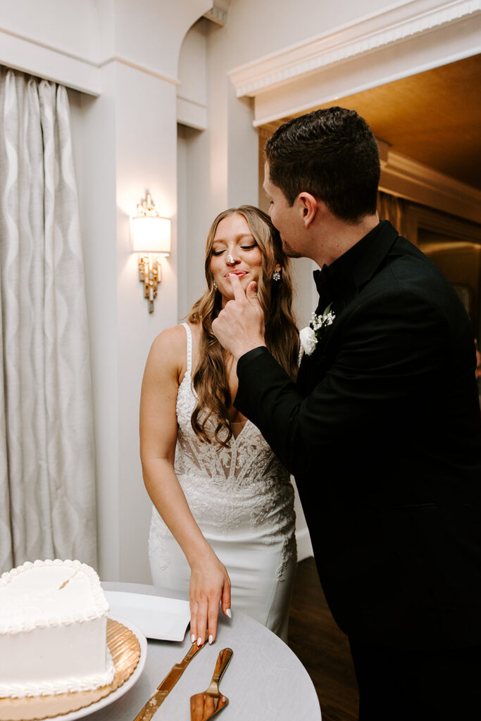 couple playfully cutting their wedding cake