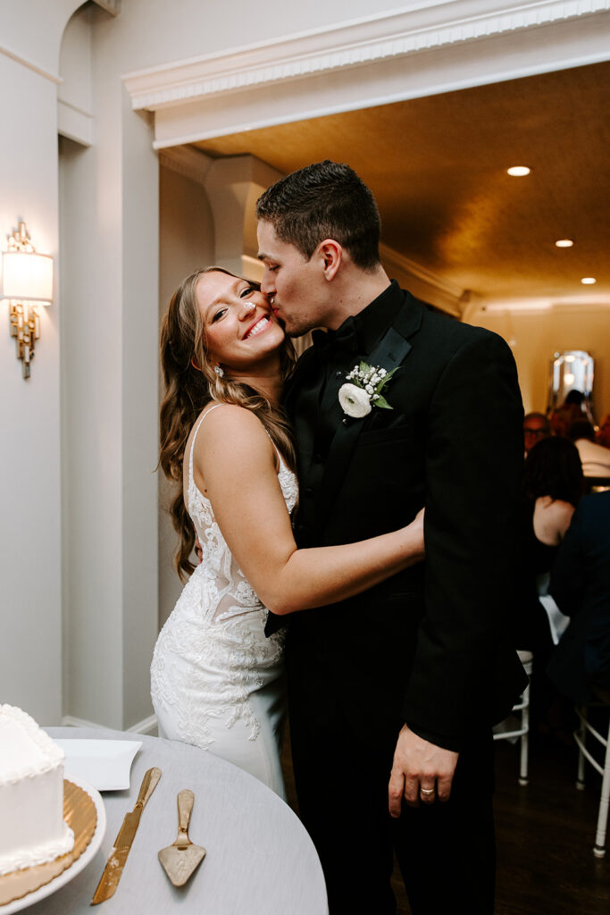groom kissing bride after cake cutting