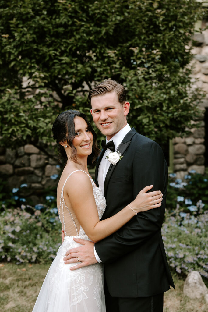 bride and groom in front of whimsical greenery