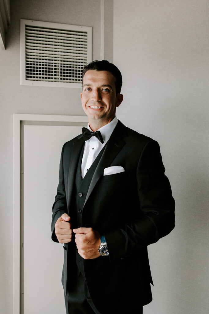 groom smiling while getting ready