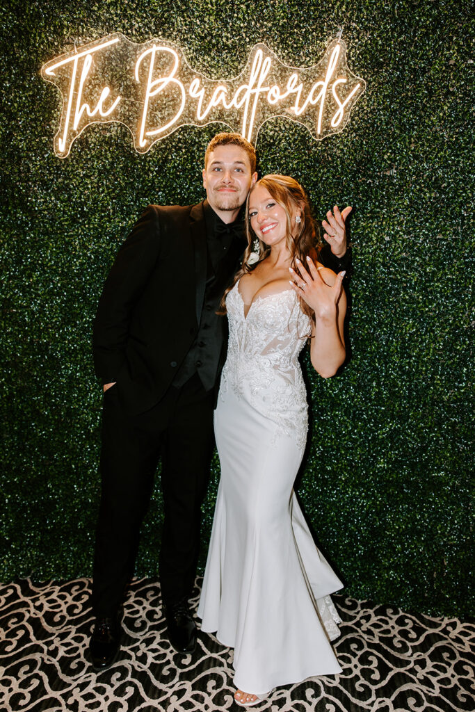 alyssa and sam in front of their wedding sign