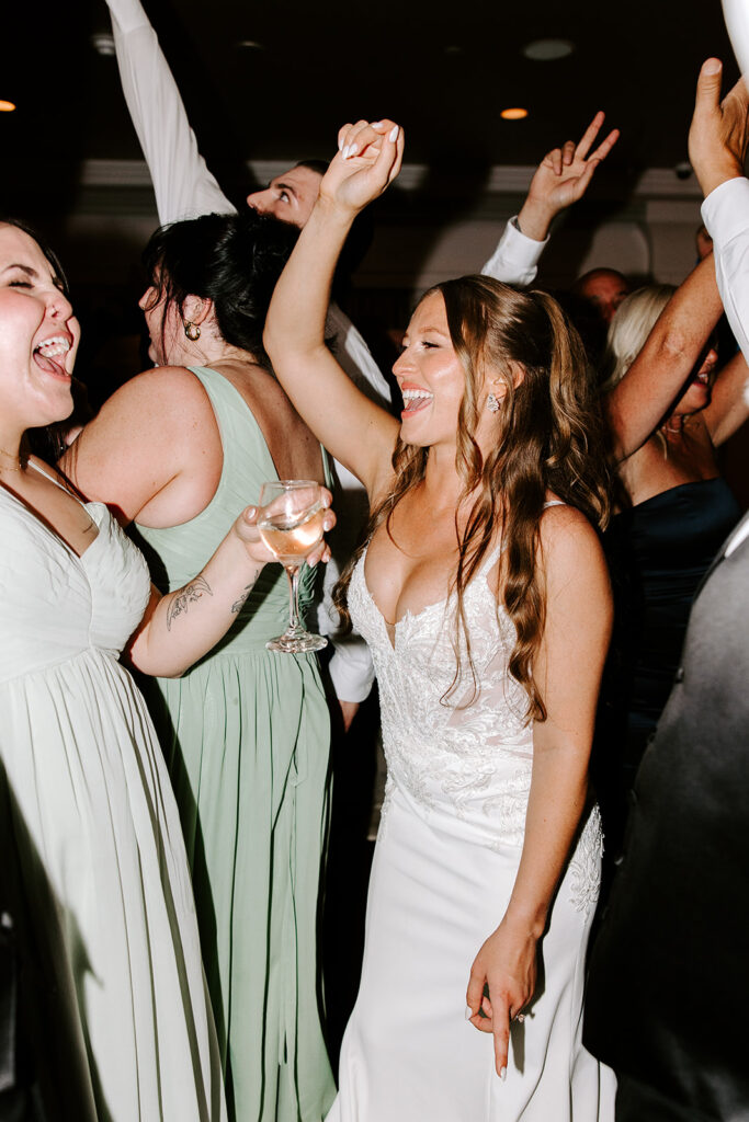 Bride and groom dancing with guests on a packed dance floor