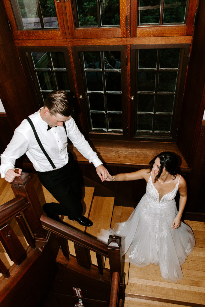 bride and groom walking downstairs hand in hand towards their reception