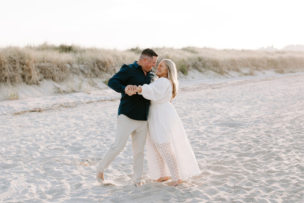 Couple walking barefoot along shoreline at Crane Beach